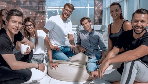 Группа творческих молодых людей, сидящих на полу в новом офисе — стоковое фото