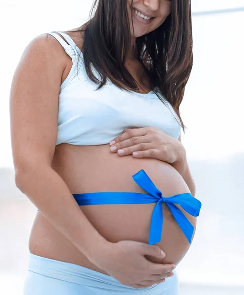 Happy pregnant woman measuring her tummy and waist. — Stock Photo, Image