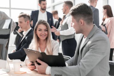 İş belgelerini tartışan çalışanlar ofis masasında oturuyorlar