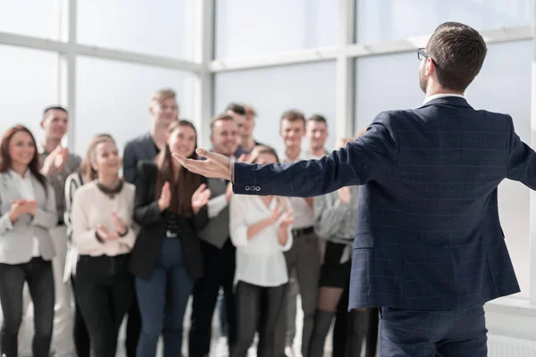 Vista trasera. el joven líder explicando algo a su equipo —  Fotos de Stock