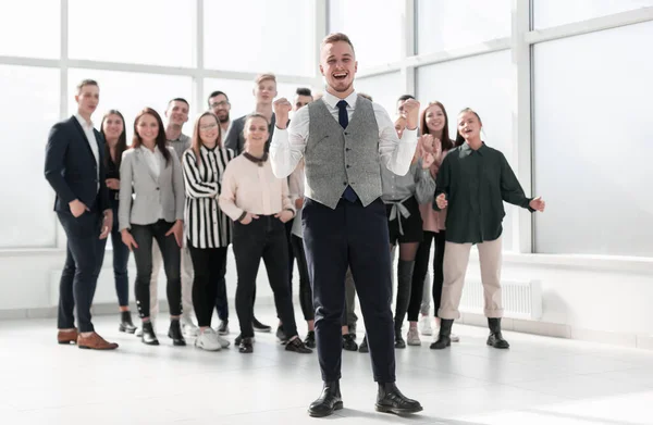 Lächelnder junger Mann vor seinen Kollegen — Stockfoto