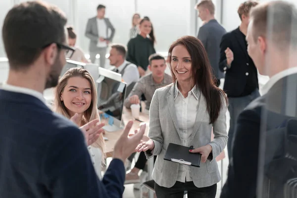 Femme d'affaires parlant à ses collègues debout dans le bureau — Photo