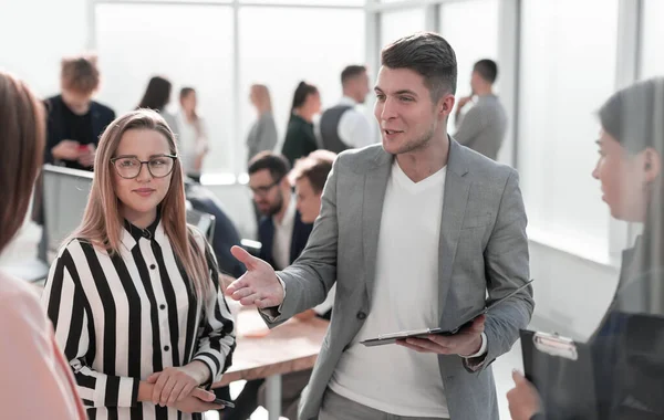 Jovem empregado explicando algo para seus colegas. — Fotografia de Stock