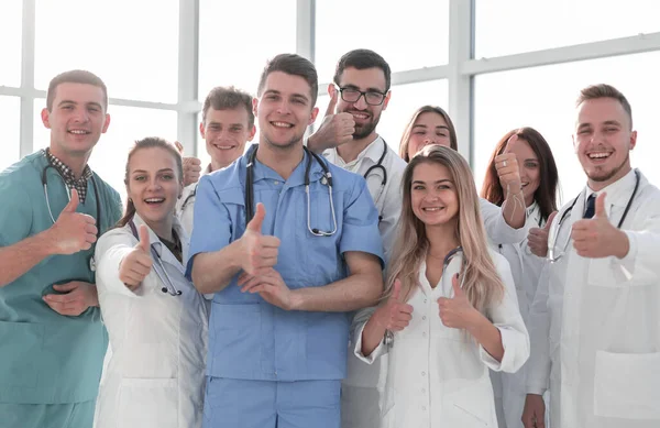 Закрывай. молодые медицинские работники показывают большие пальцы вверх — стоковое фото
