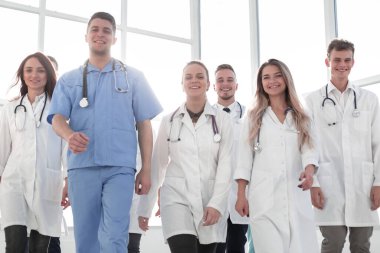 Gülümseyen tıp doktorları hastane koridorunda yürüyor..