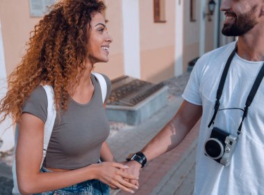 Gülümseyen mutlu turistler yürüyor ve manzaranın tadını çıkarıyor