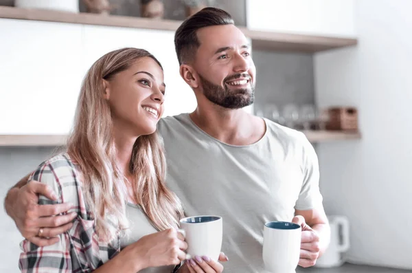 Mladý pár pití kávy stojící v kuchyni — Stock fotografie