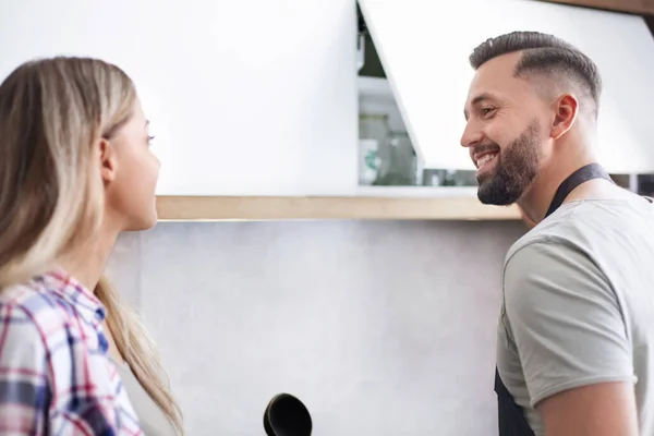 Lyckliga par diskuterar menyn stående i köket — Stockfoto