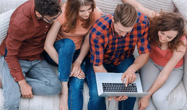 Grupo de amigos con un ordenador portátil, discutiendo el video — Foto de Stock