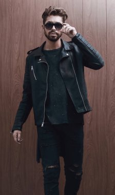 Siyah deri ceketli ve kot pantolonlu bir adam