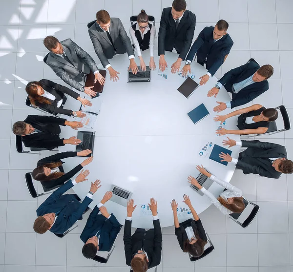 Grupo de empresarios sentados en la mesa redonda, y poniendo sus palmas sobre la mesa — Foto de Stock