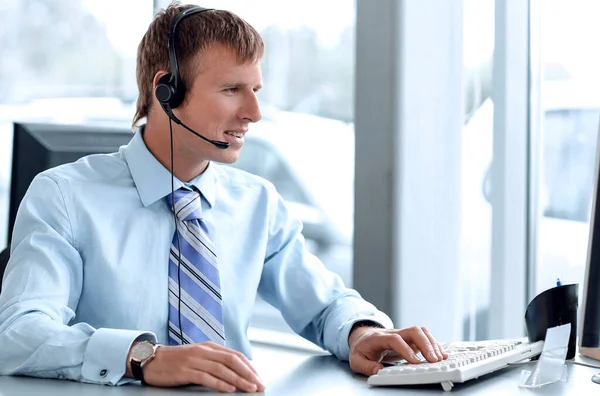 Feliz hombre de negocios en auriculares sonriendo mientras mira a la cámara . — Foto de Stock