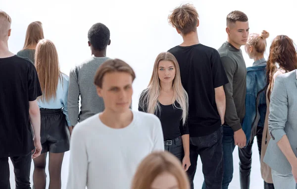 serious woman standing in front of casual group of young people