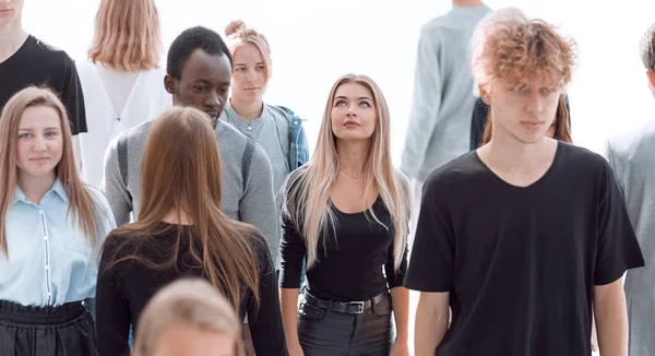 Ernste Frau steht vor lässiger Gruppe junger Leute — Stockfoto