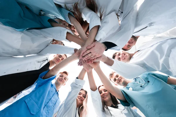 Ansicht von unten. eine Gruppe medizinischer Kollegen, die ihre Hände zusammenlegen. — Stockfoto