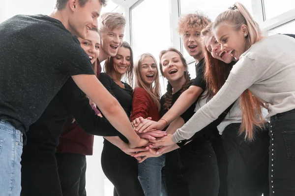 Gruppo di giovani felici che fanno una torre dalle loro mani — Foto Stock