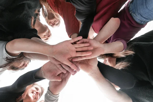 Gruppo di giovani felici che fanno una torre dalle loro mani — Foto Stock