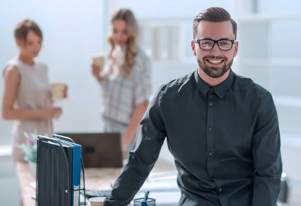 Sorridente jovem homem de negócios em pé no escritório — Fotografia de Stock