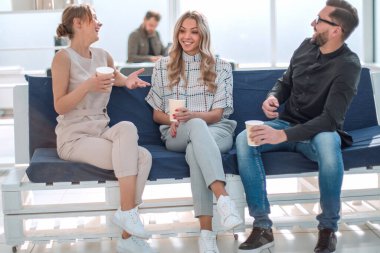 İş adamları ofis lobisinde bir şey tartışıyorlar.