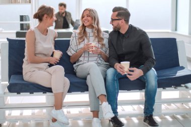 İş adamları ofis lobisinde bir şey tartışıyorlar.