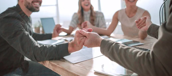 Business team zit aan tafel en toont hun eenheid — Stockfoto