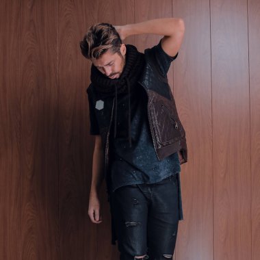 Yakışıklı genç ve formda bir adam günlük kıyafetlerle poz veriyor.