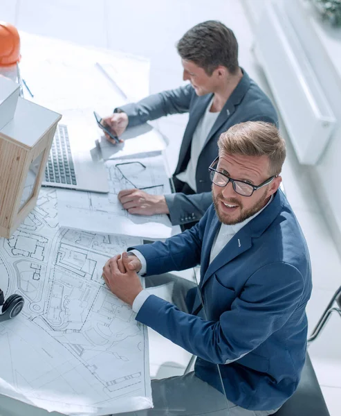 Bovenaanzicht. medewerkers van het architectenbureau aan zijn bureau. — Stockfoto