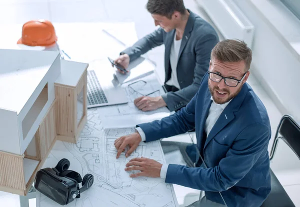 Bovenaanzicht. medewerkers van het architectenbureau aan zijn bureau. — Stockfoto