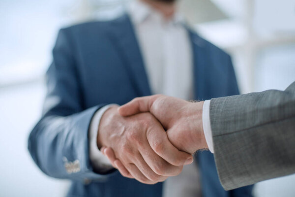 business partners greet each other standing in the office