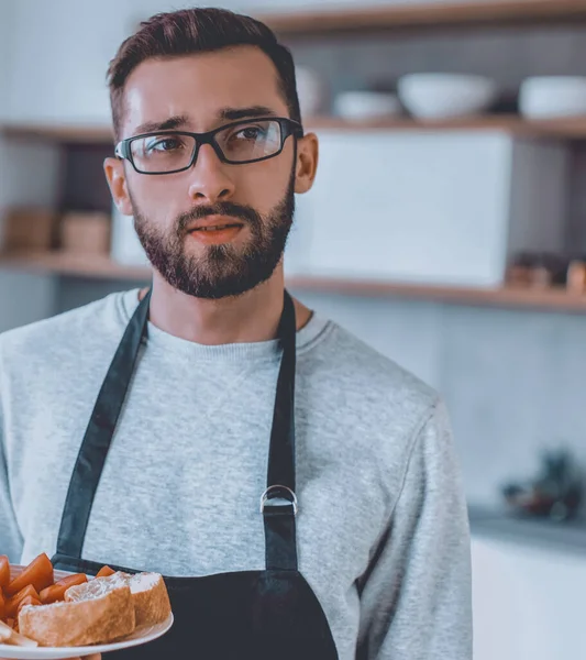 Тарелка сэндвичей в руках привлекательного мужчины — стоковое фото