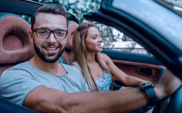 Hombre close up.stylish con su novia viajando en un coche descapotable . — Foto de Stock