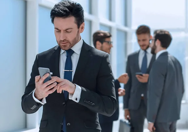 Empresario escribiendo SMS en el teléfono inteligente — Foto de Stock