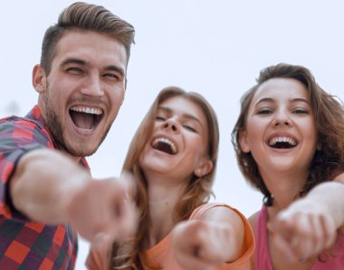 Yaklaşan üç genç insan el kaldırıyor.