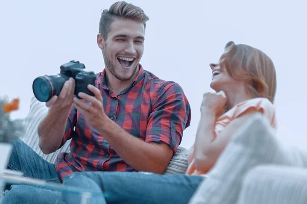 Moderna pareja joven riendo y discutiendo las fotos en la cámara — Foto de Stock