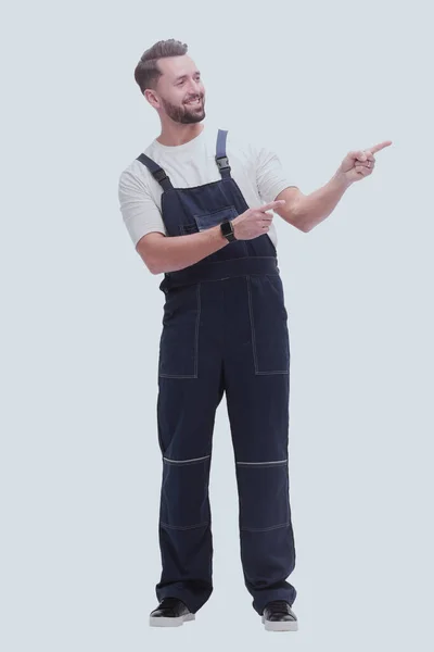 Smiling man in overalls pointing to a copy of the space — Stock Photo, Image