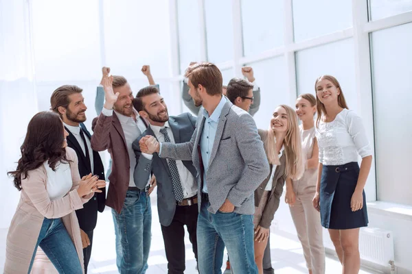 Joven empresario que acepta las felicitaciones de sus colegas . — Foto de Stock