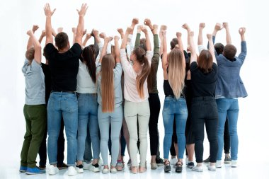 Bir grup genç insan ellerini kaldırarak ayakta duruyor.