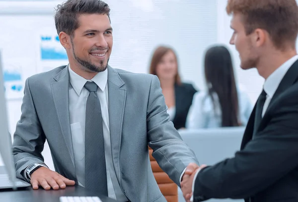 Händedruck von Geschäftspartnern am Schreibtisch. — Stockfoto