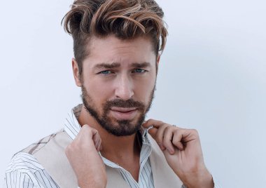 Bir adam beyaz gömleğin yakasını düzeltir.