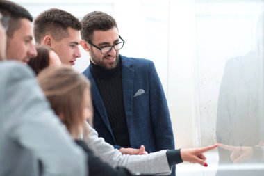 Genç çalışanlar cam duvardaki hatırlatıcıları okuyorlar.