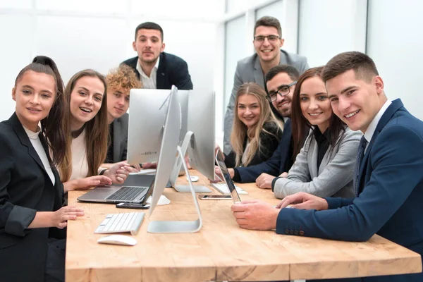 Equipe de jovens profissionais sentados em um escritório Desk — Fotografia de Stock