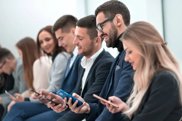 Gruppe junger Leute, die in der Warteschlange sitzen — Stockfoto