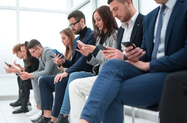 Gruppe von lässigen jungen Leuten, die ihre Geräte benutzen . — Stockfoto