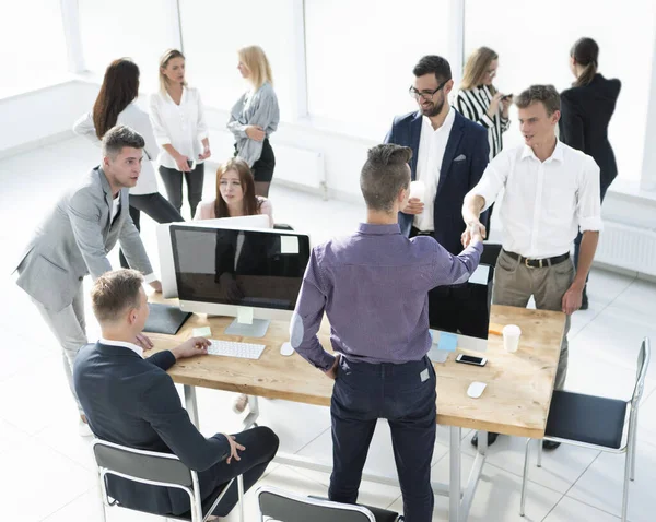 Collega 's uit het bedrijfsleven begroeten elkaar bij het bureau. — Stockfoto