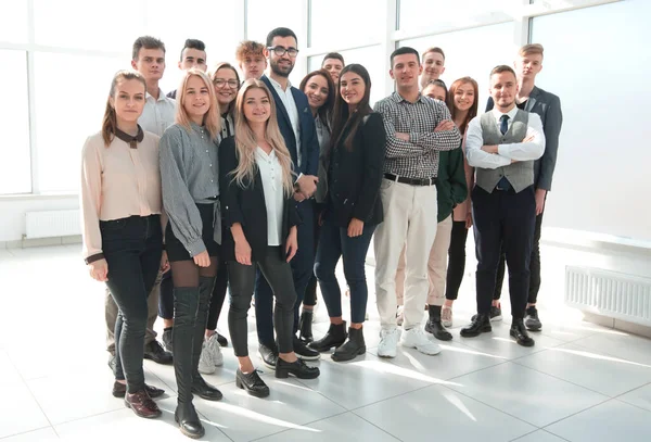 Группа различных счастливых людей, стоящих в новом офисе — стоковое фото