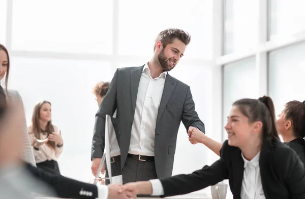 Empleados felices estrechando las manos sobre el escritorio . — Foto de Stock