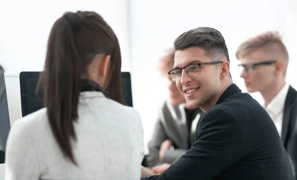 Jovem empresário sentado entre seus colegas em uma reunião . — Fotografia de Stock