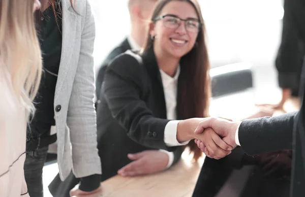 De près. femme d'affaires souriante serrant la main de son partenaire d'affaires — Photo