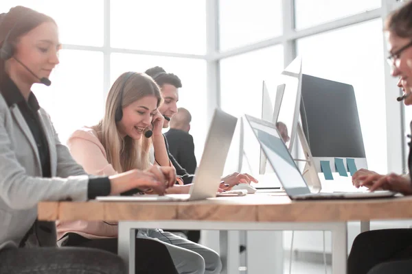 Groep werknemers in een headset werkt aan een bureau. — Stockfoto