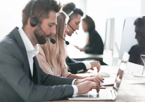 Operadores de call center usando laptops para trabalhar com clientes — Fotografia de Stock